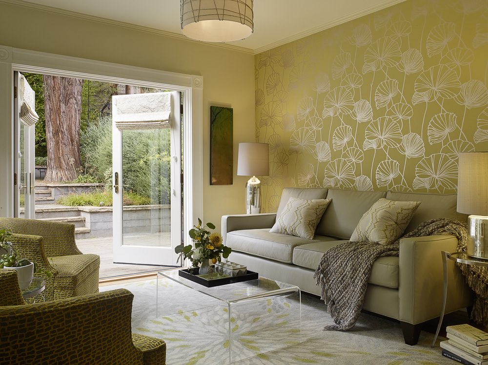 اتاق نشیمنی که ترکیب کاغذ دیواری و نقاشی دیوارها به رنگ زرد در آن استفاده شده است